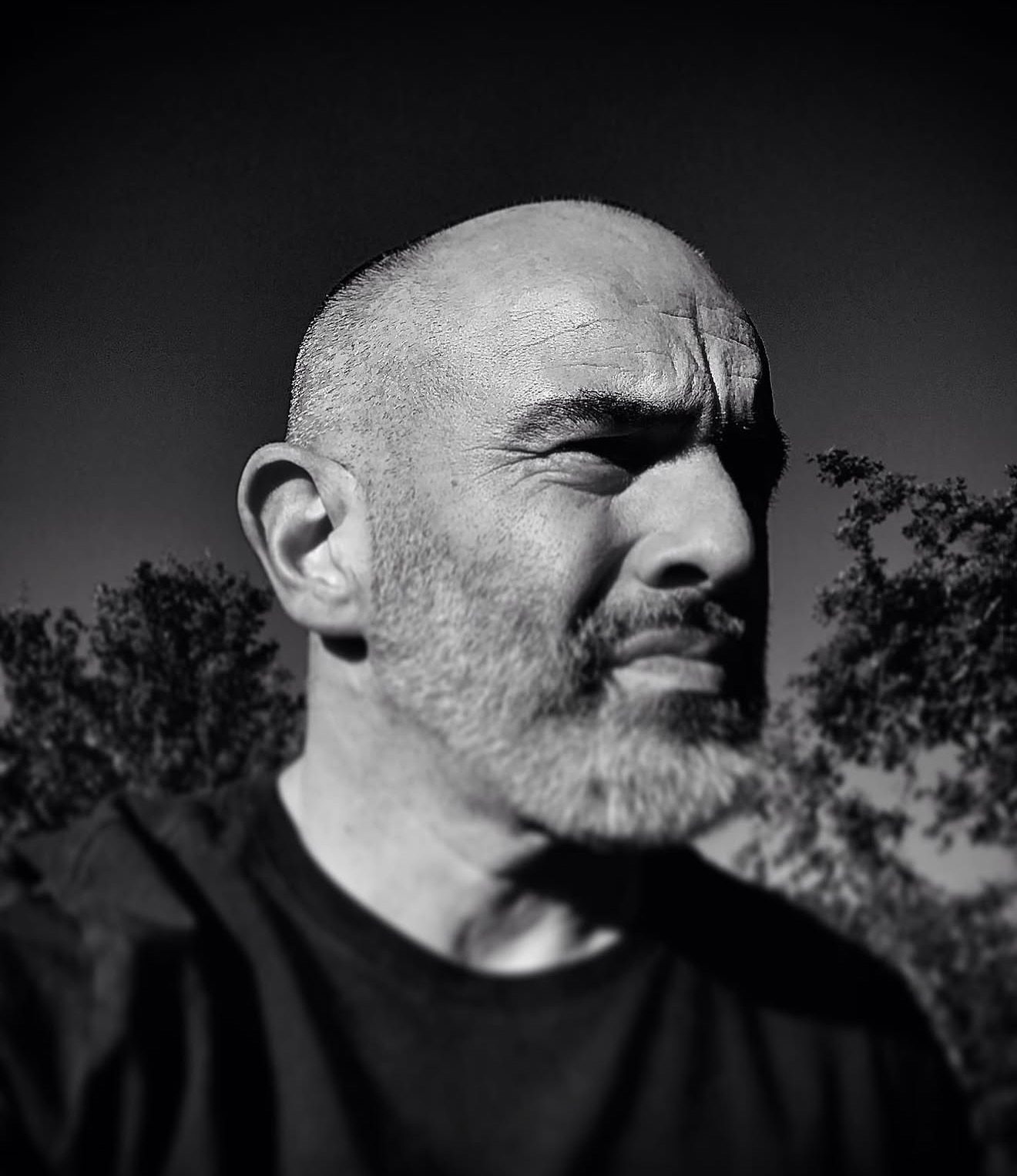 Black and white portrait of the founder against northern trees